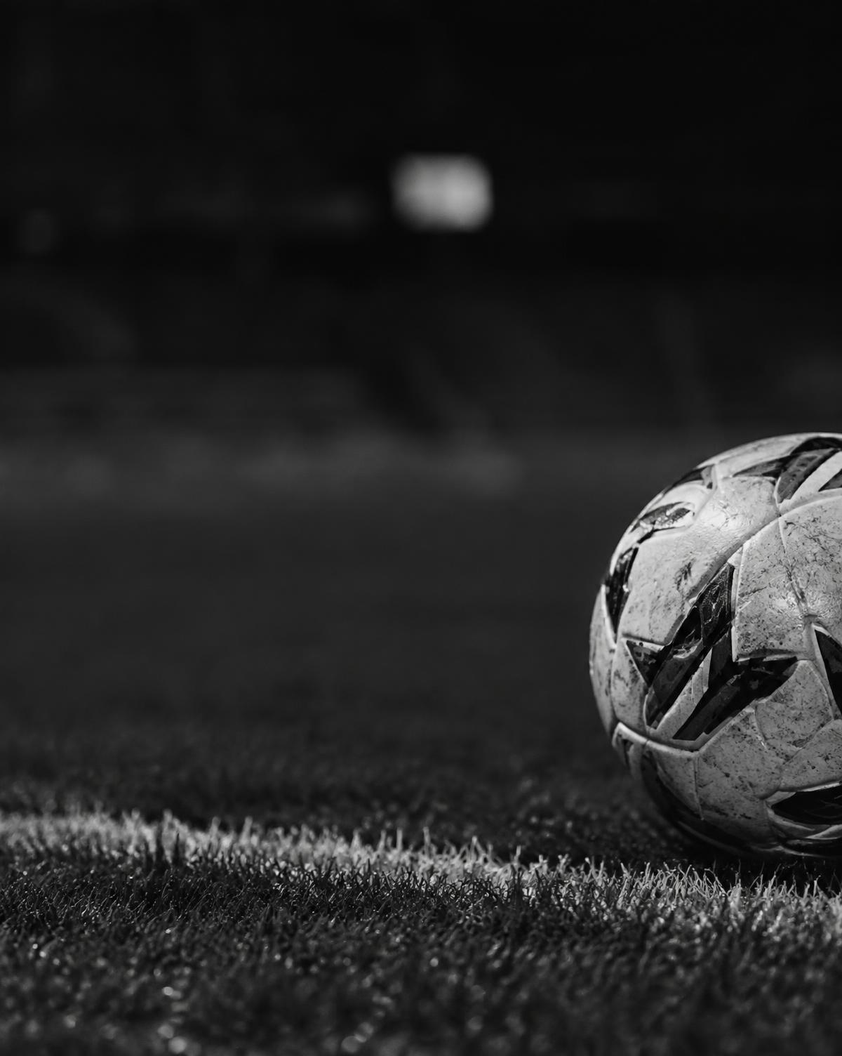 Football resting on the pitch line